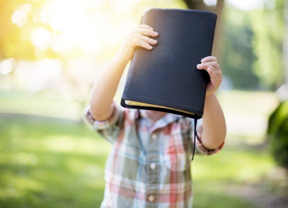 Selective focus shot of a person holding a black notebook