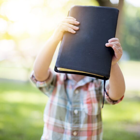 Selective focus shot of a person holding a black notebook