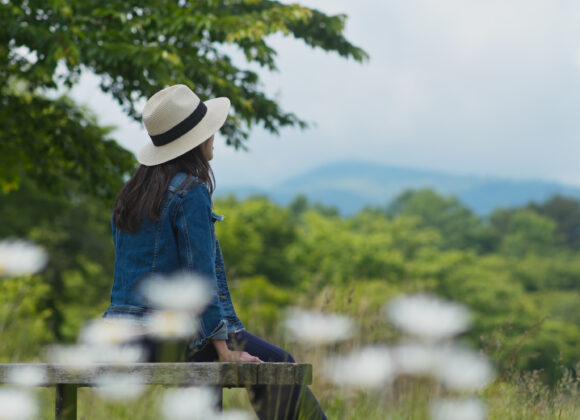 Woman look around the landscape and sit on the wooden bench