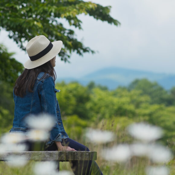Woman look around the landscape and sit on the wooden bench
