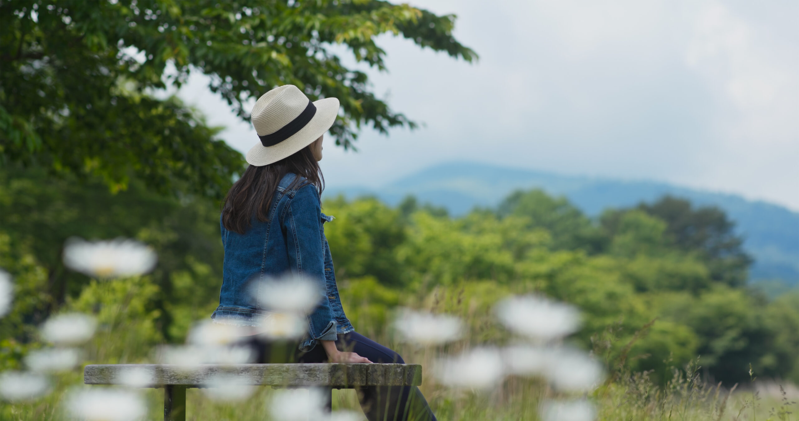 Woman look around the landscape and sit on the wooden bench
